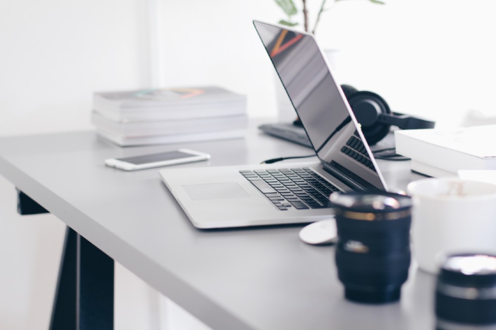 Laptop and phone on white table - working from home